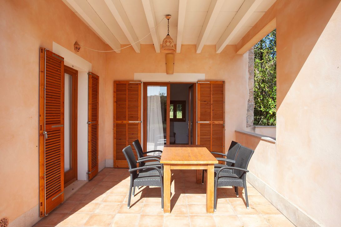 Eine Terrasse mit Tisch und Stühlen darauf