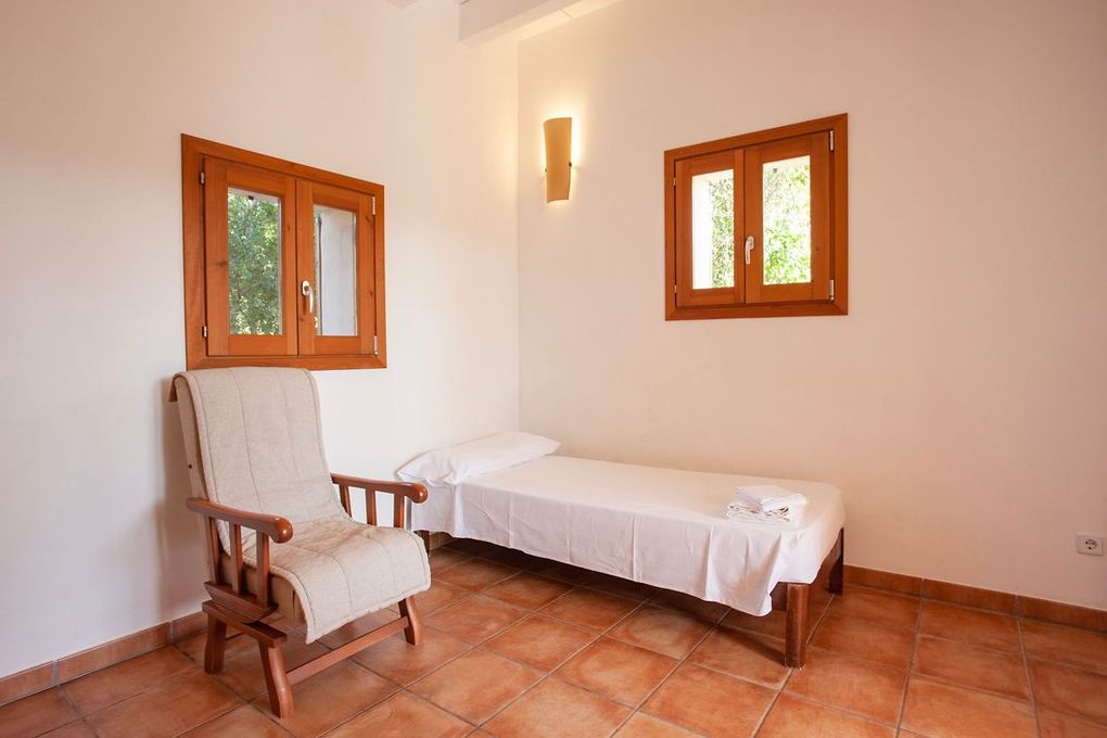 Hay una silla y una cama en la habitación.