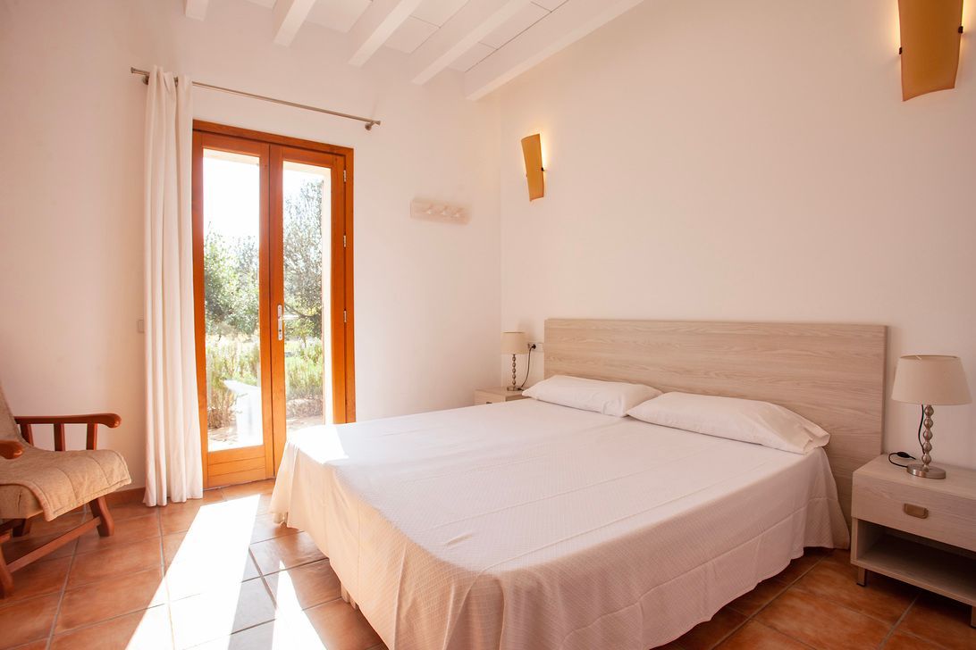 Ein Schlafzimmer mit einem großen Bett und einem Sessel