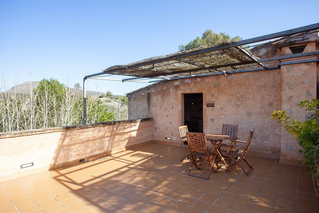 Un patio con una mesa y sillas bajo un dosel.