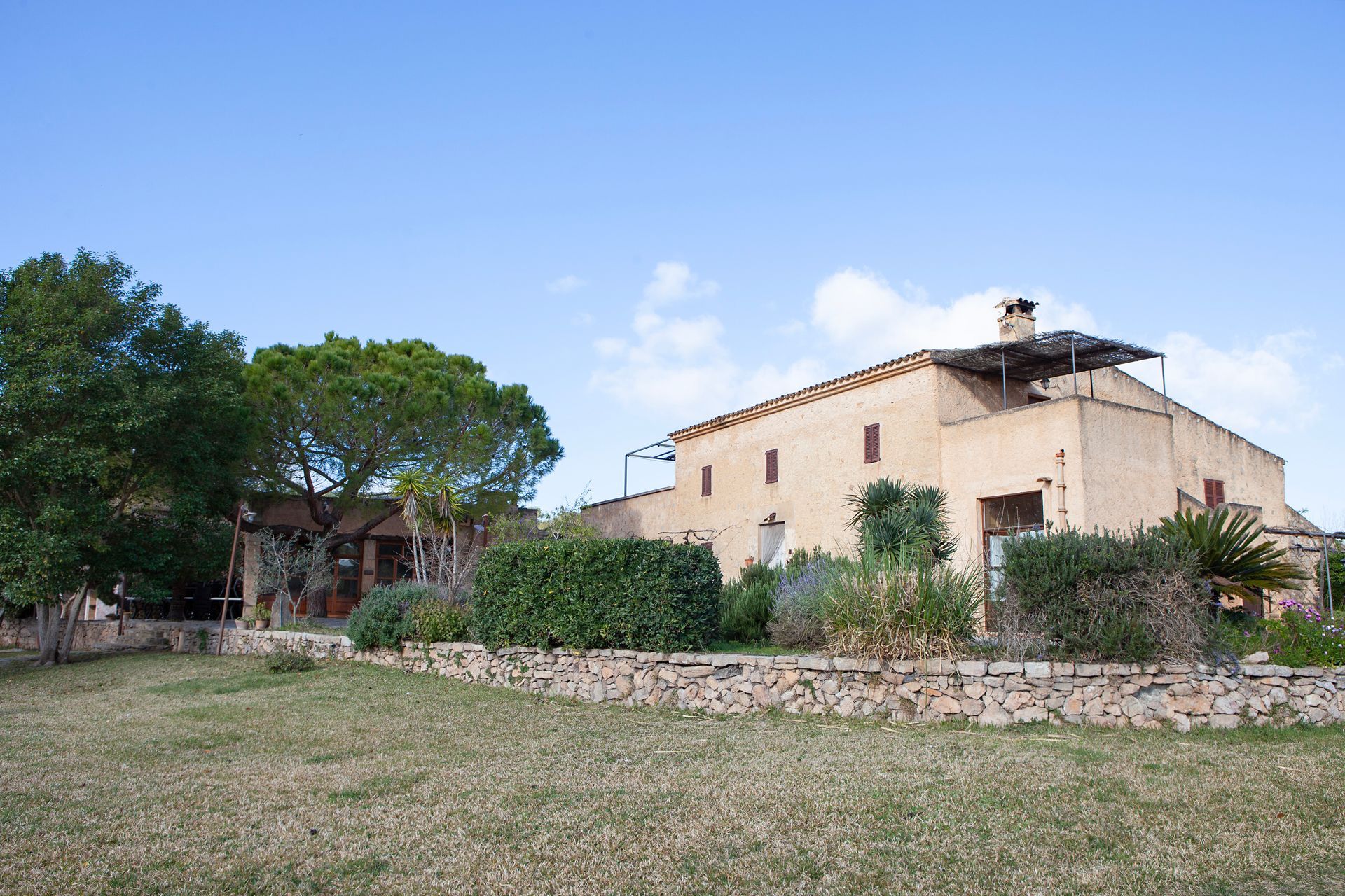 Una casa grande con un muro de piedra al frente.