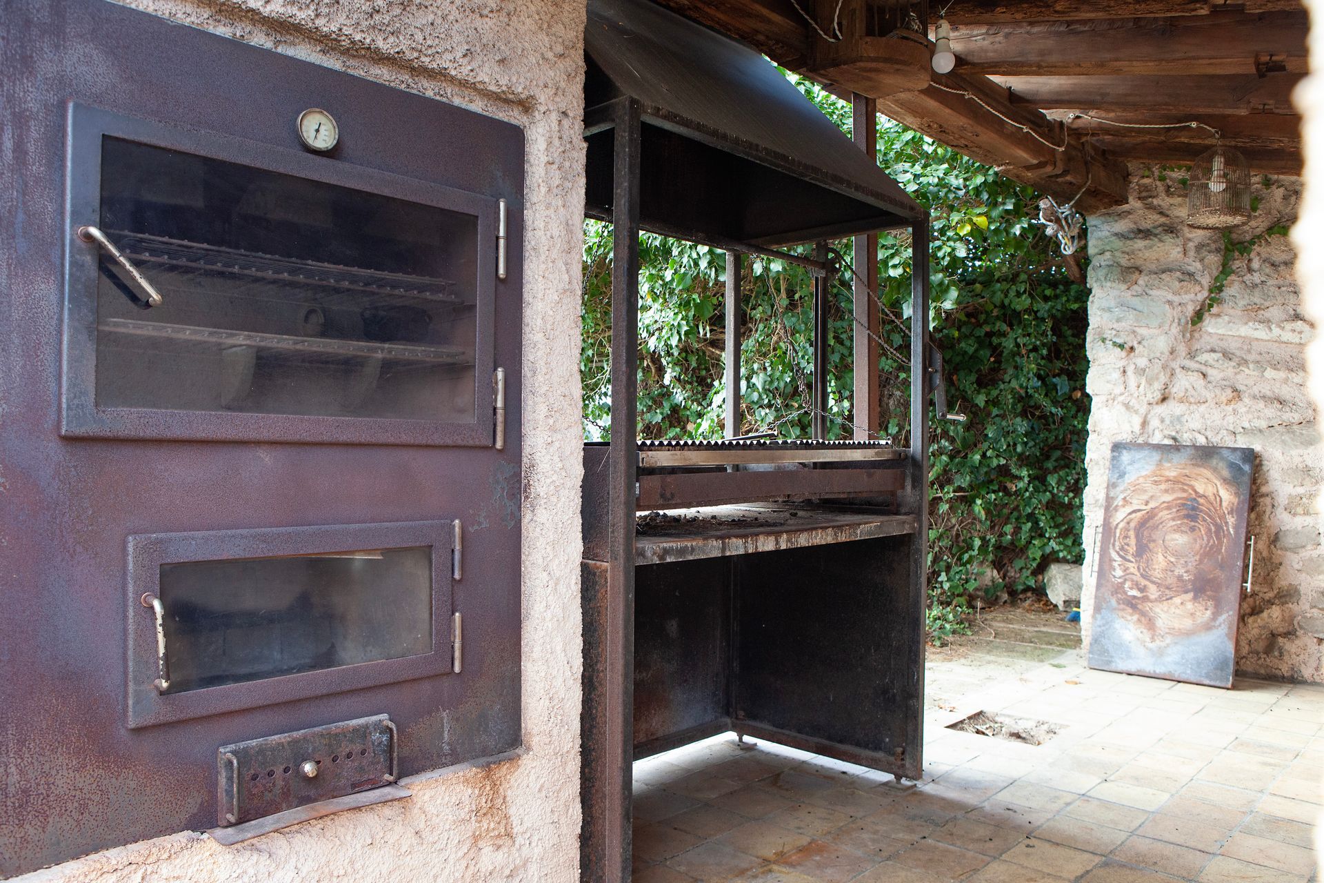 Un horno oxidado está al lado de una parrilla.