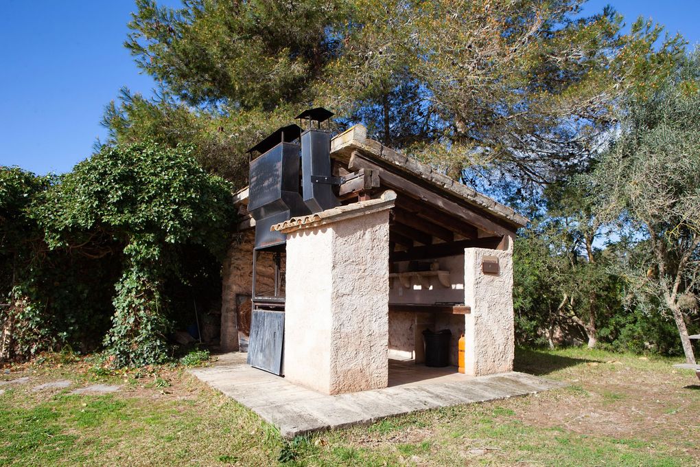 Un pequeño edificio de piedra con una chimenea en la parte superior.