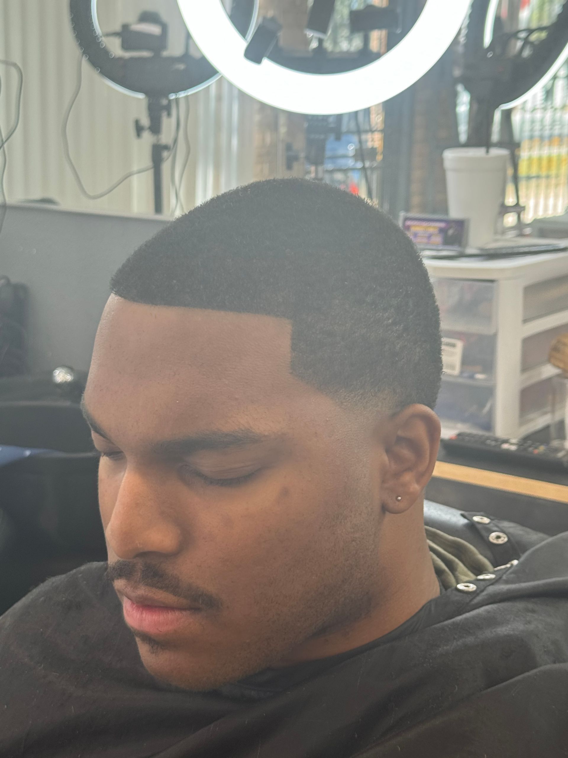 A man is getting his hair cut at a barber shop