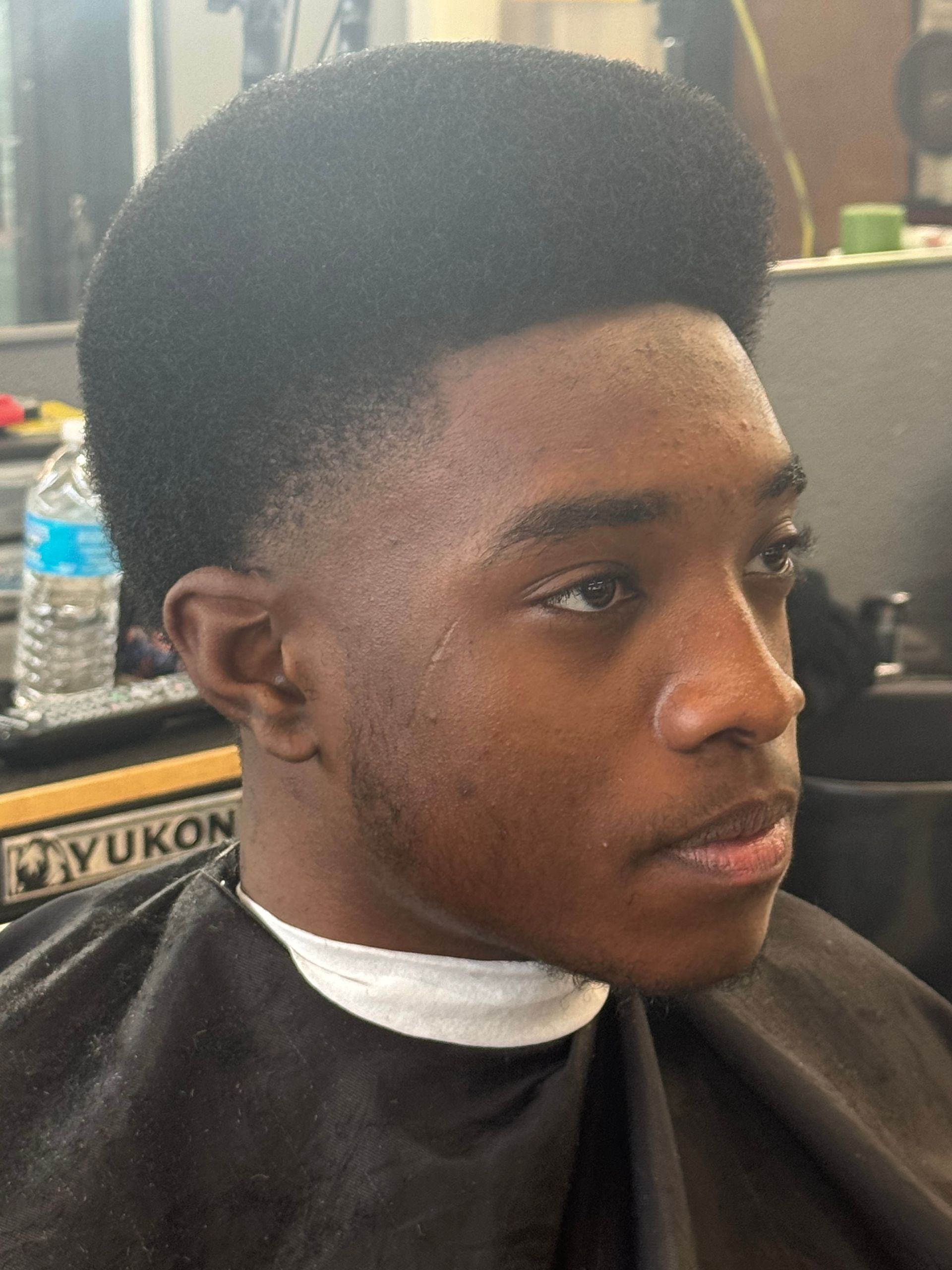 A young man is getting his hair cut at a yukon barber shop