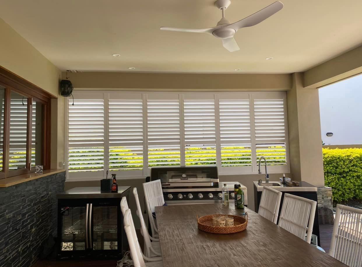 Charming Kitchen Ambiance with Table, Chairs, Shutters, and Ceiling Fan — Window Coverings in Gold Coast, QLD