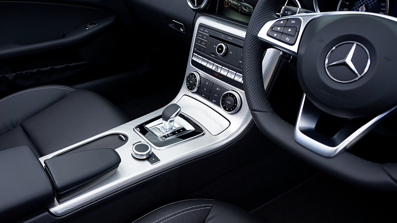 Mercedes-Benz car interior with black seats, silver center console, and steering wheel visible
