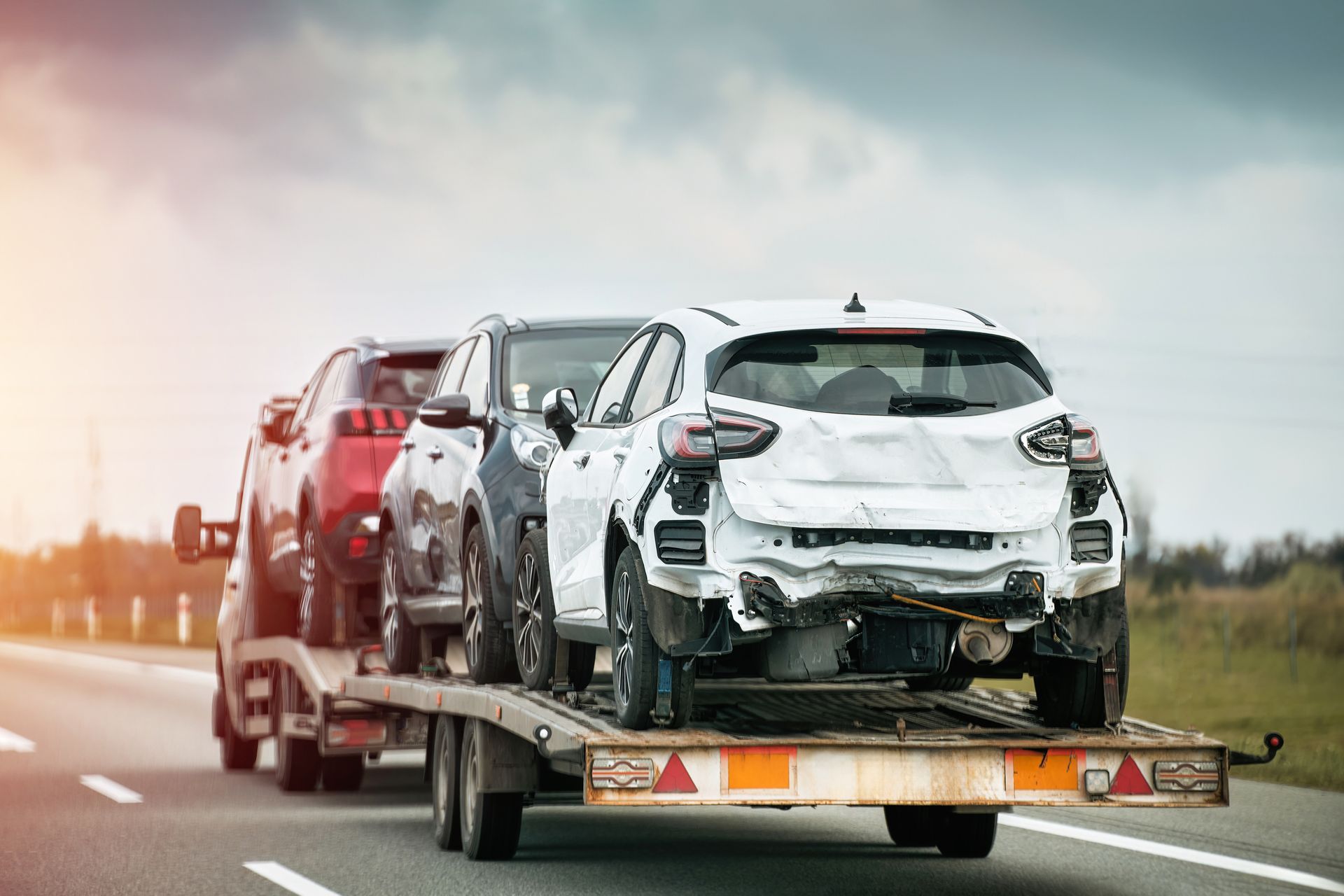 Tow truck carries three cars damaged beyond repair. Tow truck carries three cars damaged beyond repair.