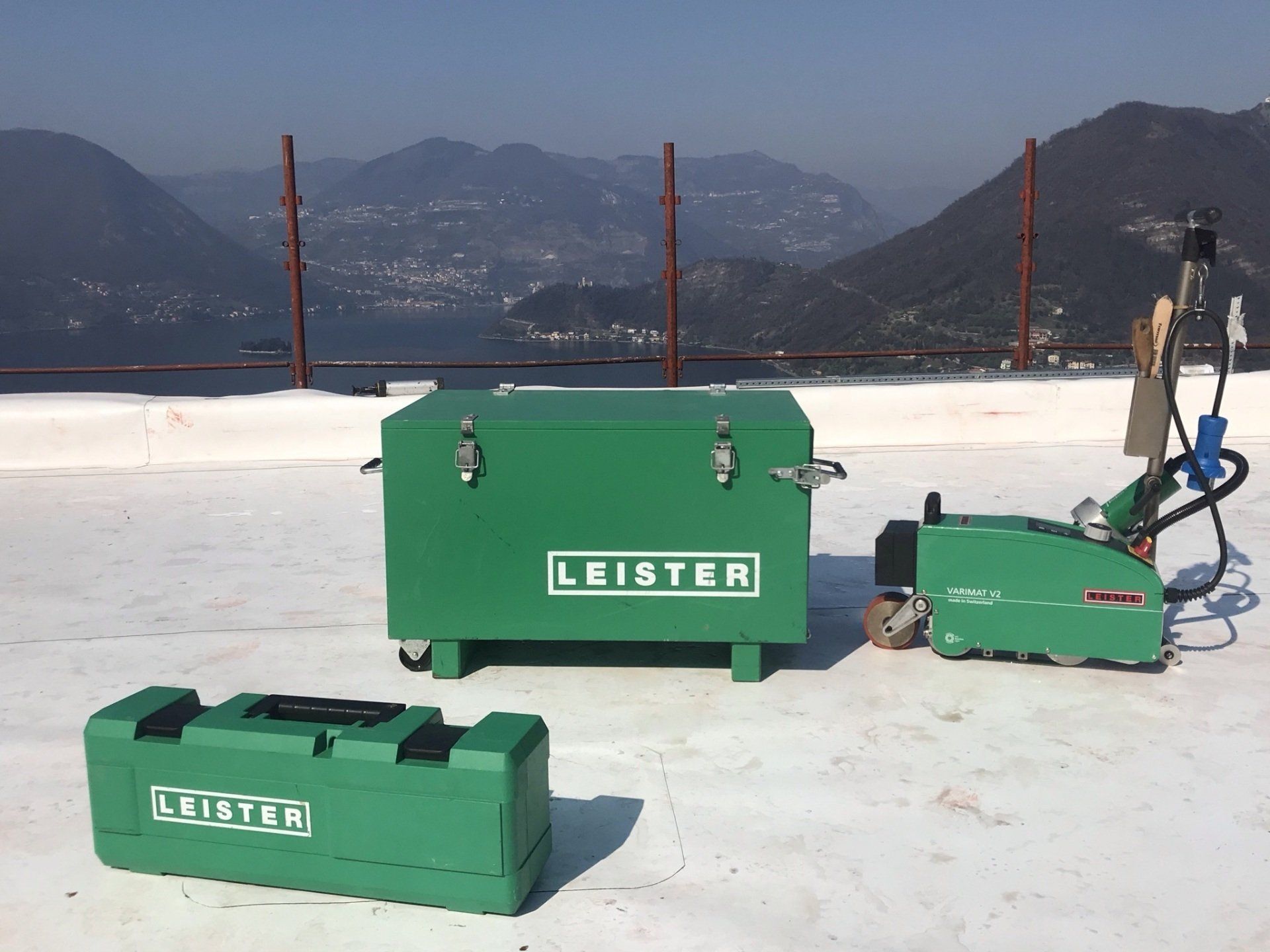 Attrezzatura LEISTER verde su un tetto innevato con le montagne sullo sfondo.