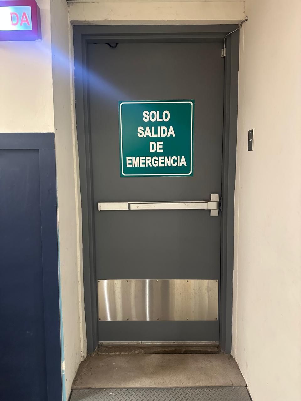 Gray emergency exit door with Spanish sign 