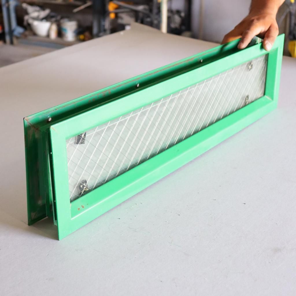 Buzón metálico verde con ventana rectangular de cristal.