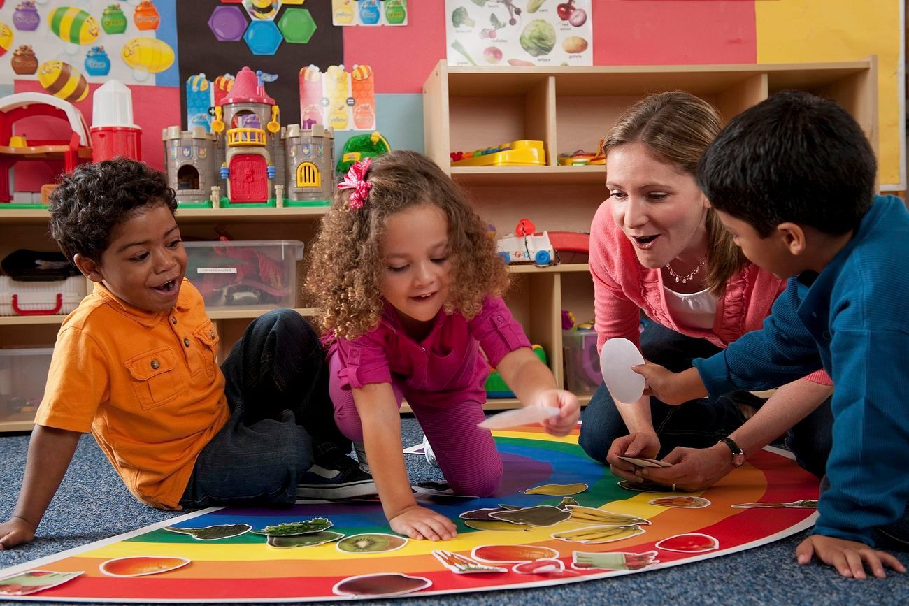 A group of children are playing with a puzzle on the floor.