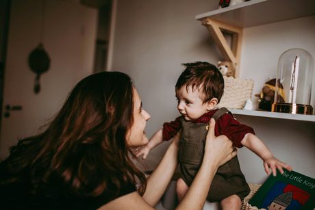 A woman is holding a baby in her arms in a room.