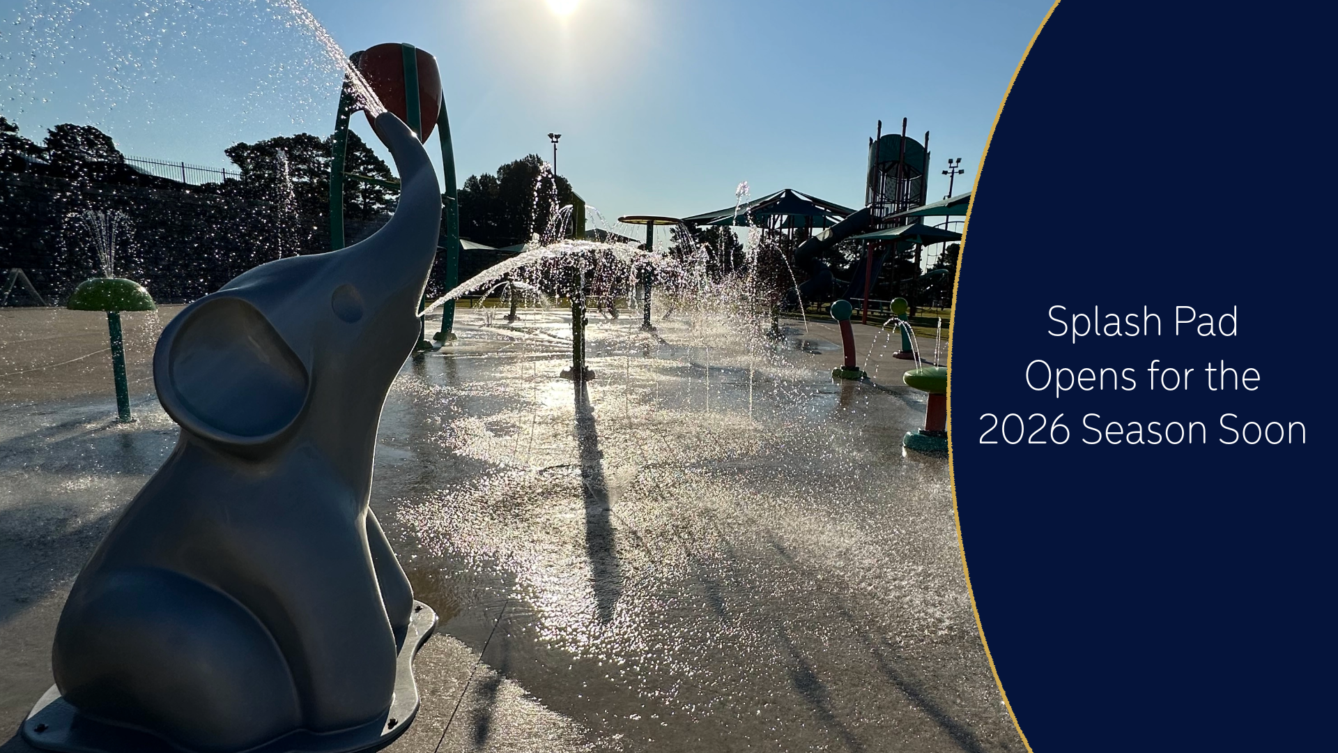 Splash pad with water jets and a sign reading “Opens for the 2026 season soon”