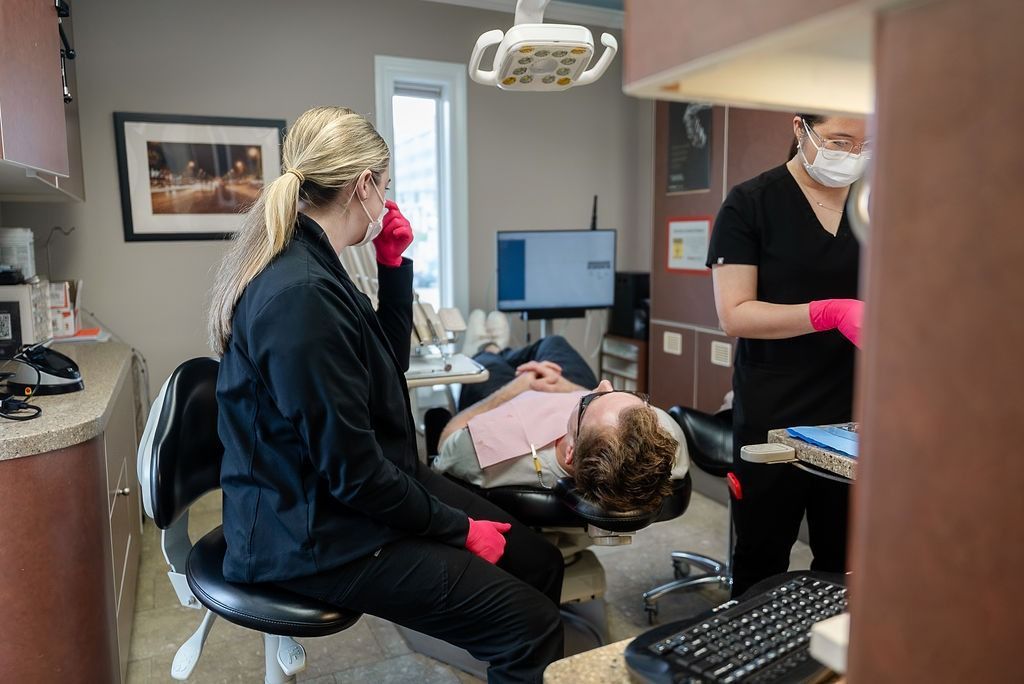 Dentist and assistant treating a patient in a dental clinic