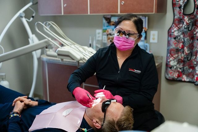 Dentist treating a patient in a dental chair Dentist treating a patient in a dental chair