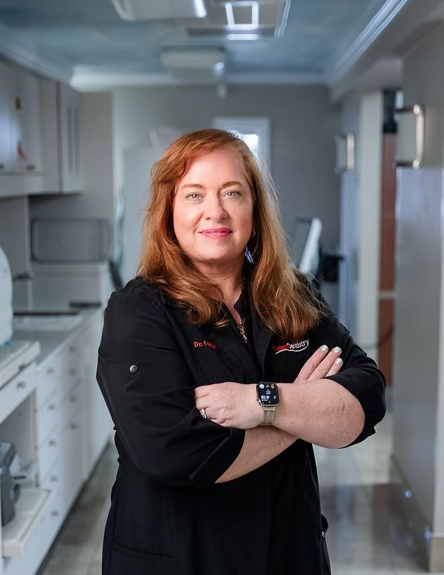 Woman with crossed arms standing in a bright kitchen hallway