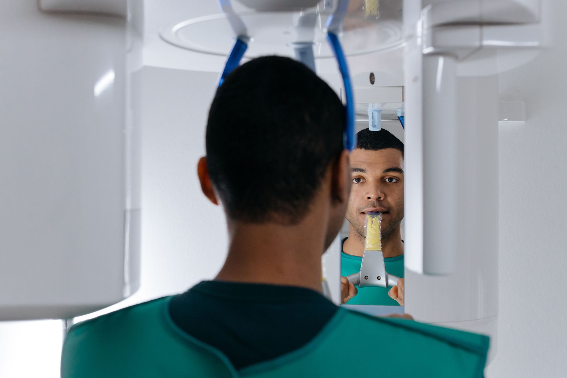 Patient in dental X-ray machine, seen from behind