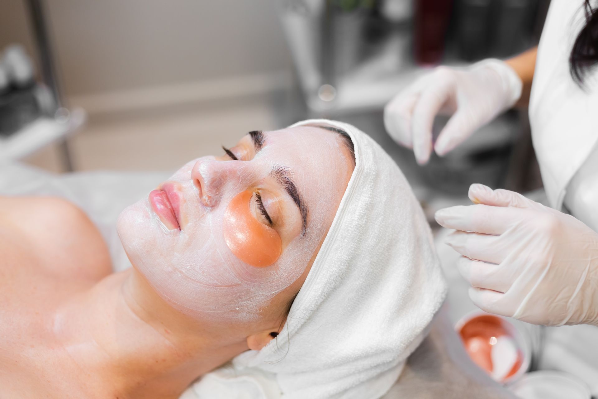 A skincare specialist using a firming treatment or device to restore elasticity and tighten the skin during a professional facial session