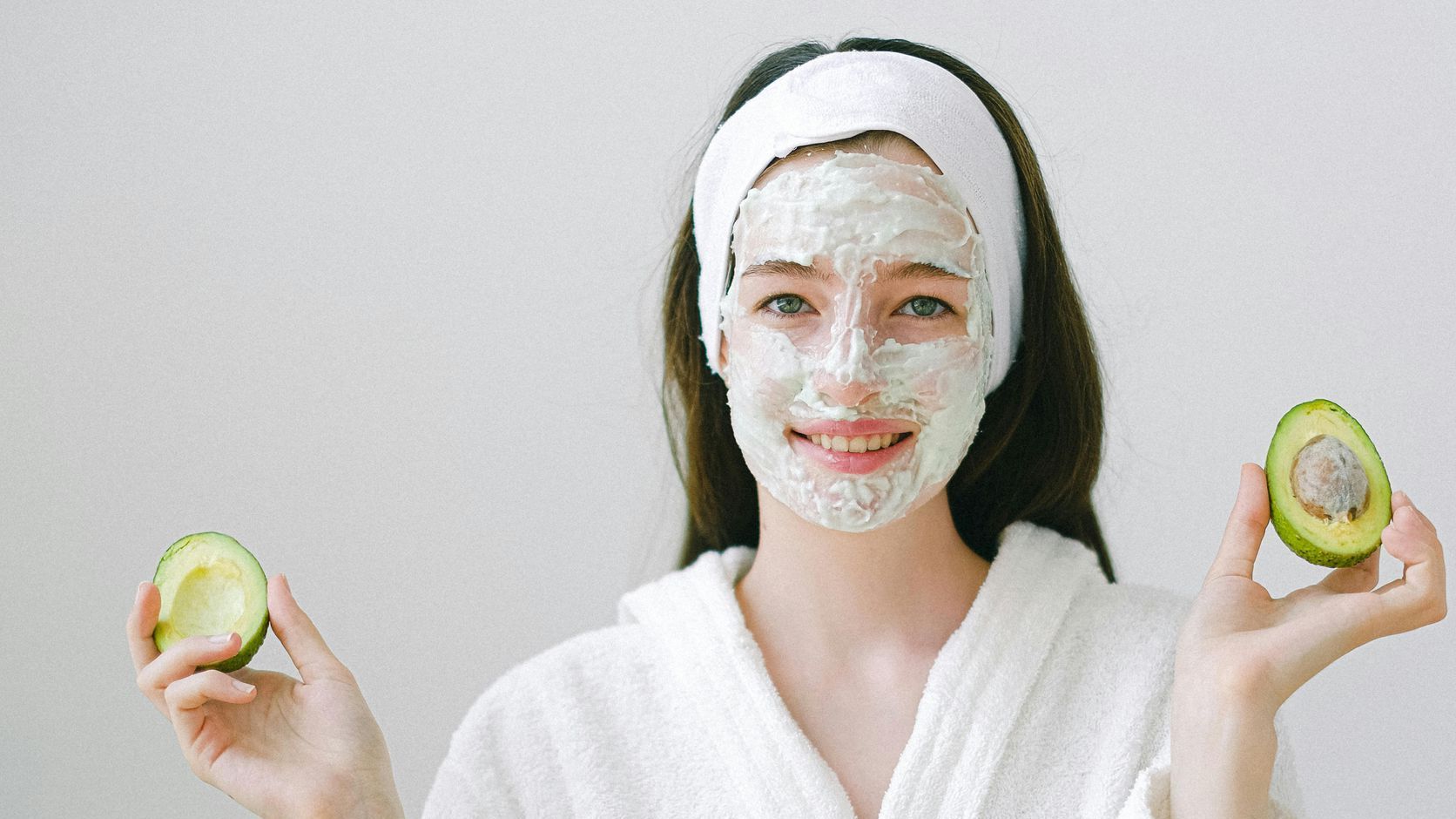 Woman enjoying the Devine Signature Facial with a hydrating face mask, promoting radiant and nourished skin.