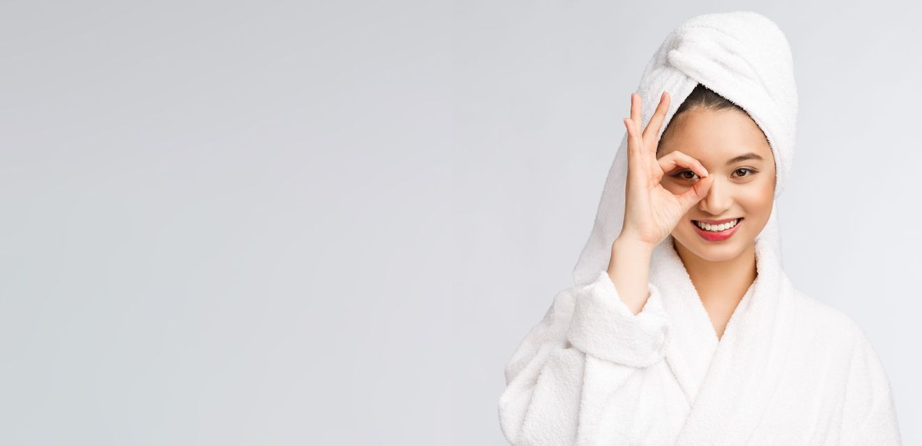 Close-up of a woman applying a rejuvenating serum to her face for a radiant glow