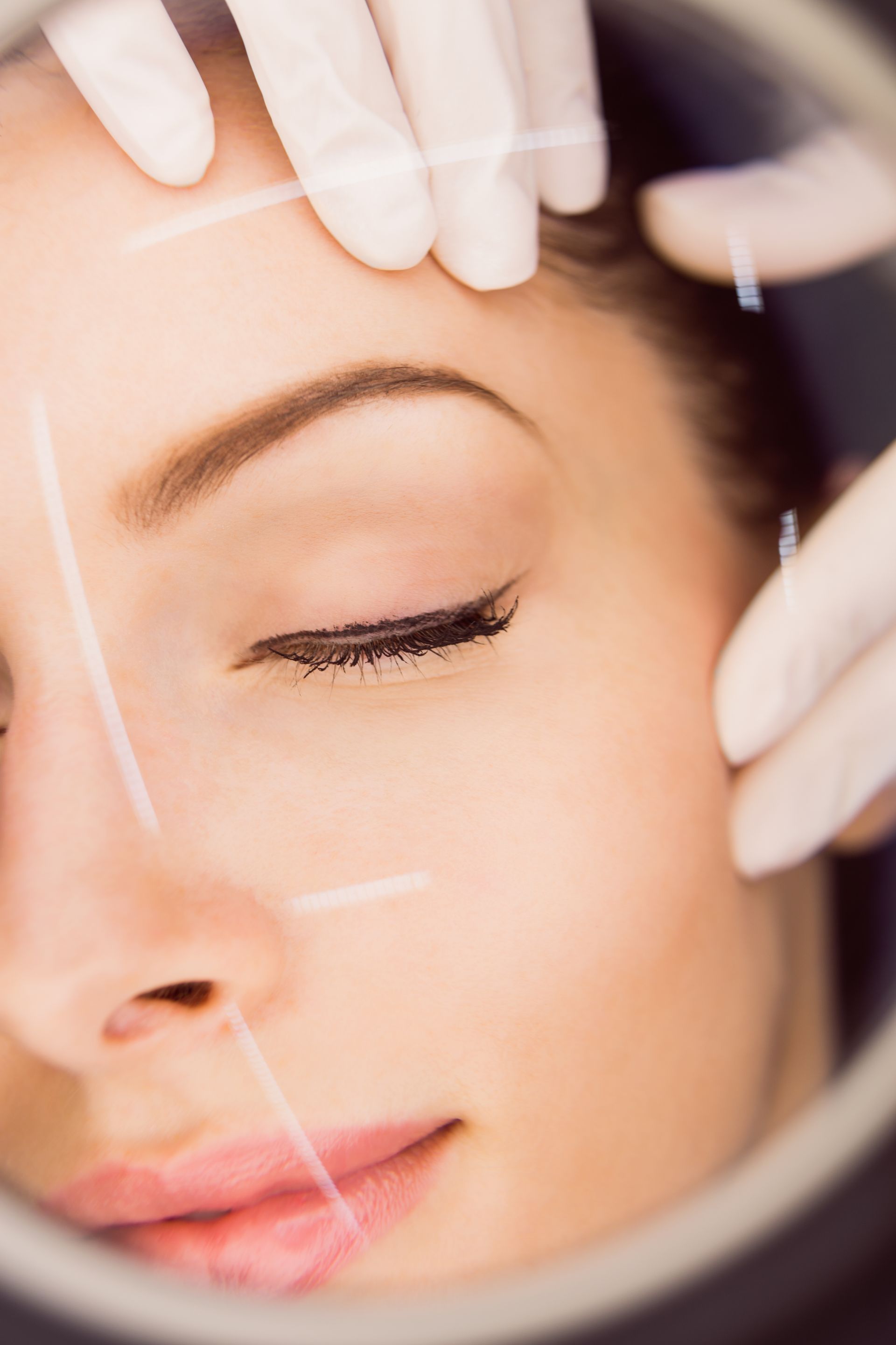 A spa therapist using a gentle exfoliation tool on a woman’s face during a rejuvenating facial session.