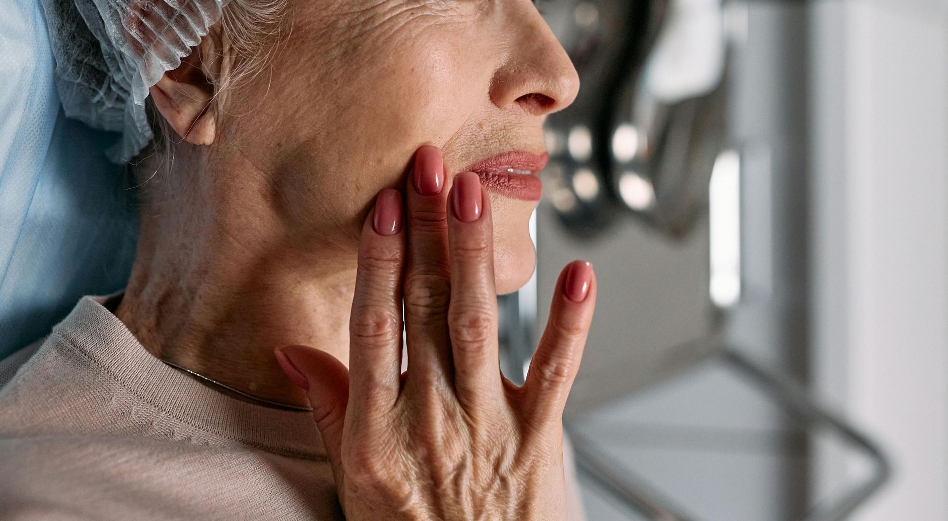 A mature woman gently touching her face, showcasing the benefits of the Menopausal Skin Facial at Devine Medspa, designed to restore hydration, elasticity, and radiance during menopause.
