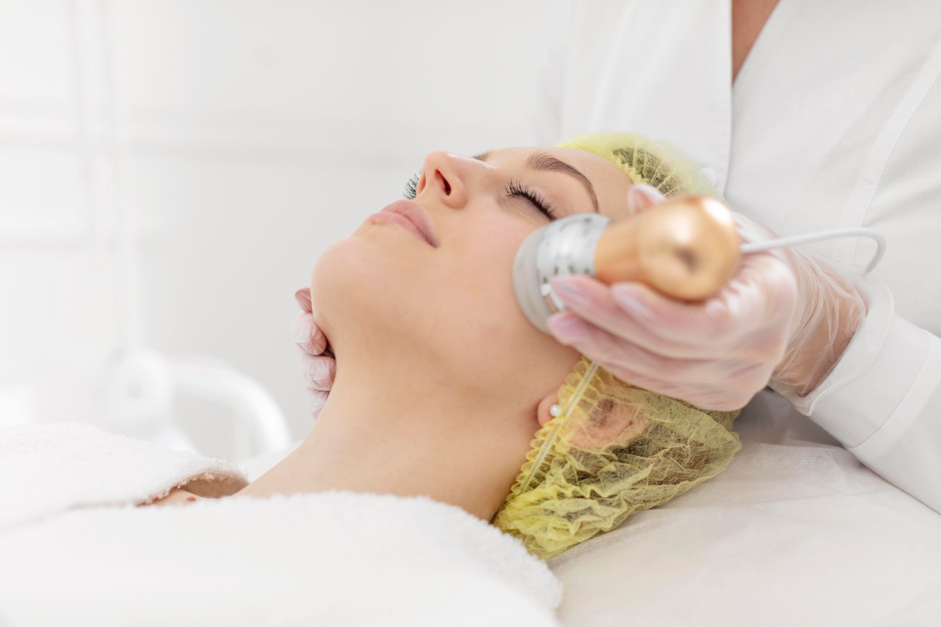 Woman undergoing microdermabrasion with Vitamin C infusion for brighter skin.
