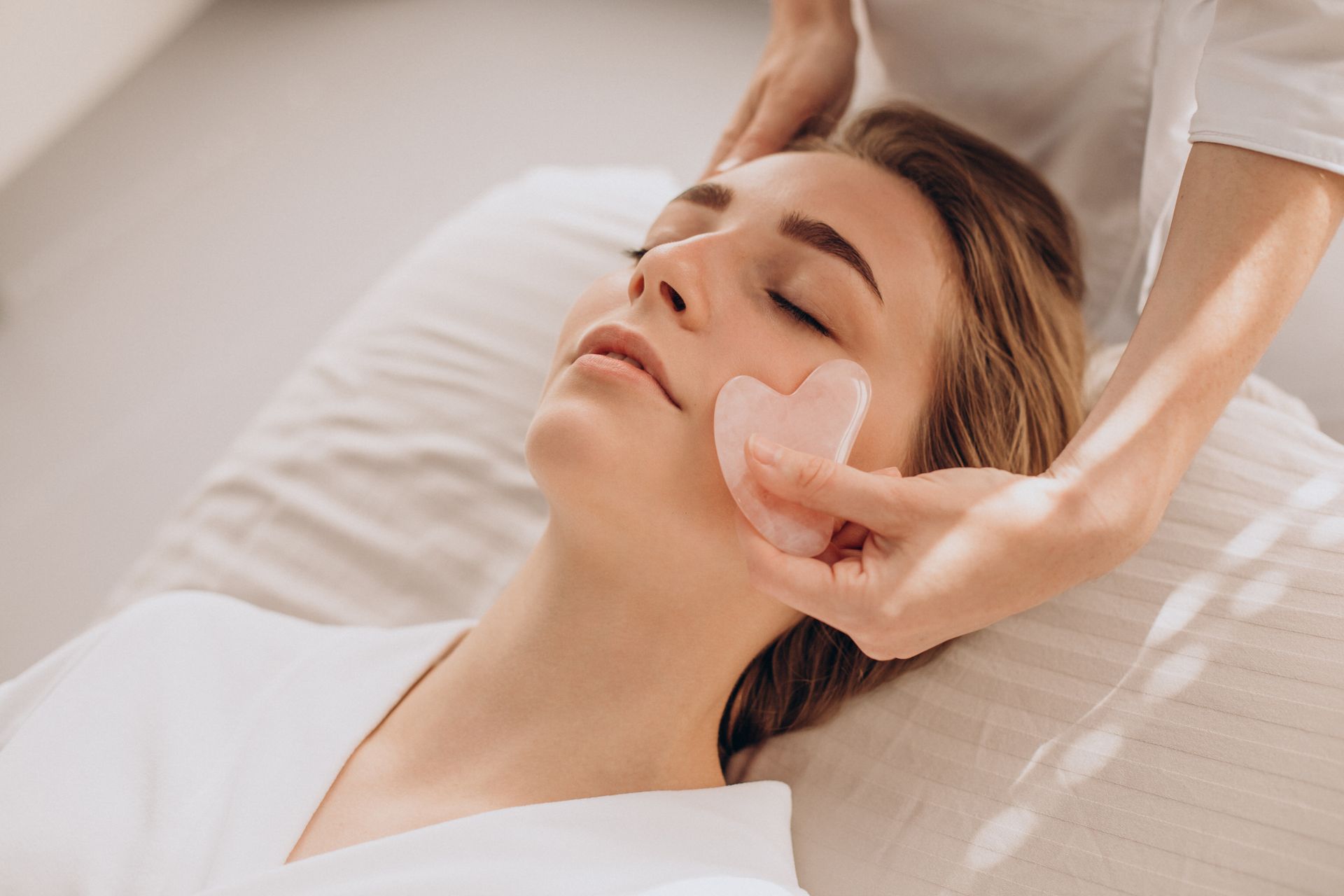 A skincare professional gently massaging a woman’s face during a luxurious spa facial.