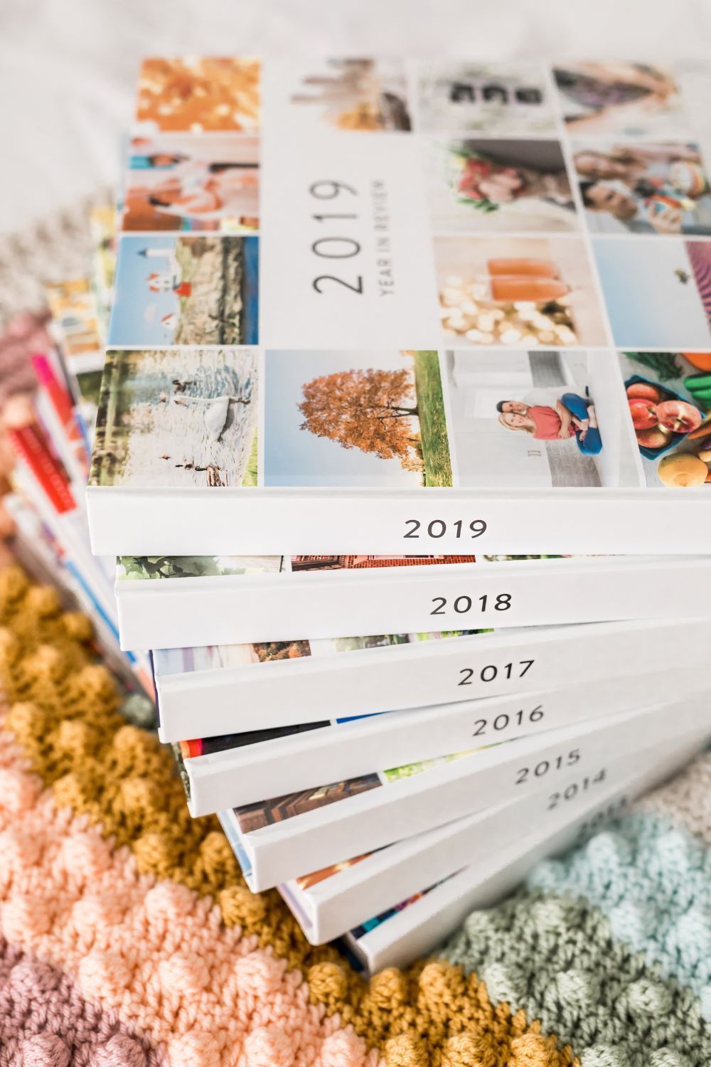 A row of books with pictures on them are sitting on a table.