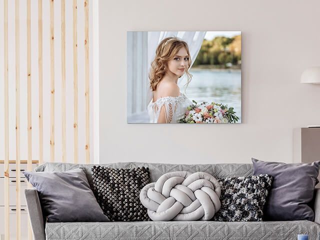 A living room with a couch and a picture of a bride on the wall.