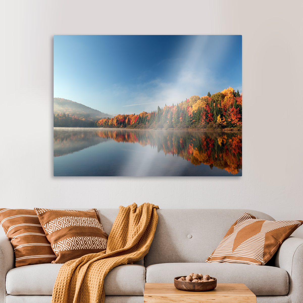 A living room with a couch and a painting of a lake