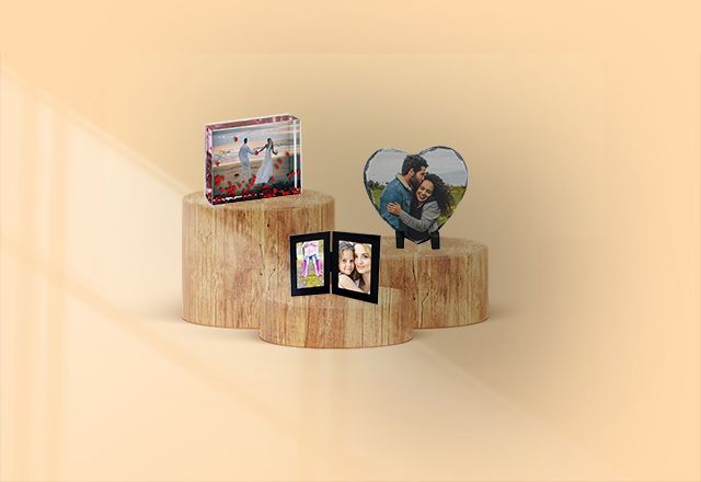 Three wooden blocks with pictures on them are sitting on top of each other on a table.