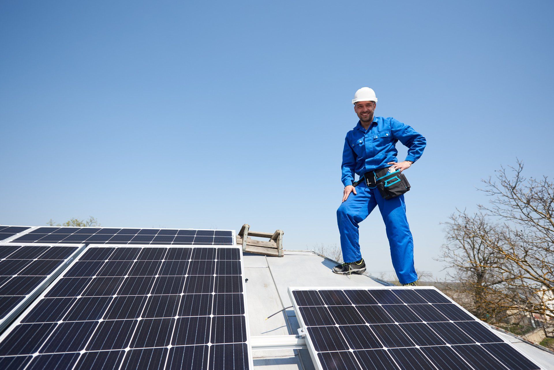 Ein Mann steht auf einem Dach mit Solarmodulen.