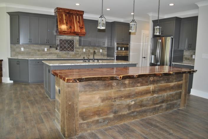 Kitchen with gray cabinets, wooden island, and stainless steel appliances.
