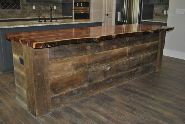 Rustic kitchen island with a live-edge wooden countertop and reclaimed wood siding.