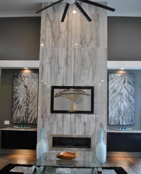 Living room with marble fireplace, artwork, and modern furniture.