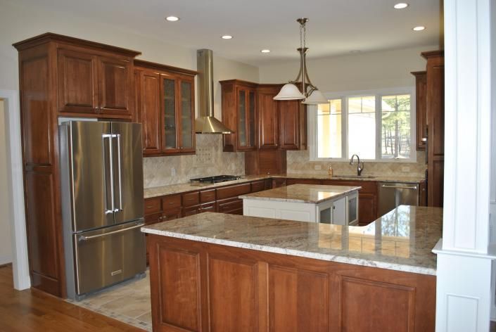 Wooden kitchen with granite countertops, stainless steel appliances, and island.
