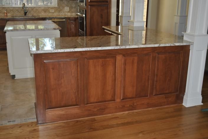 Kitchen island with wood paneling and granite countertop.