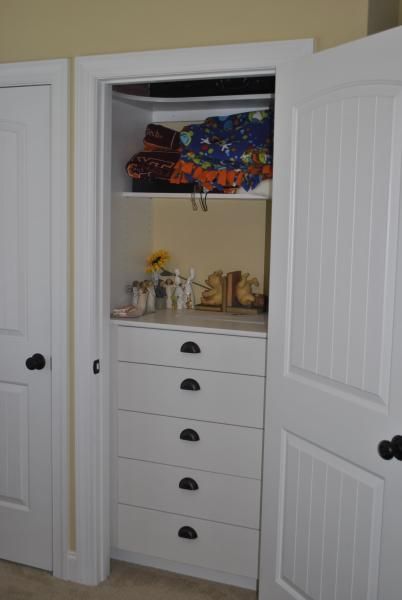 White closet with drawers; top shelf holds folded clothes.