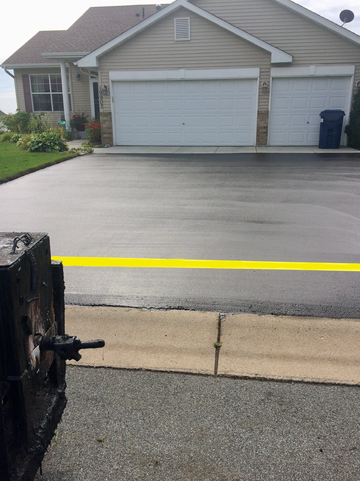 There is a yellow line on the road in front of a house.