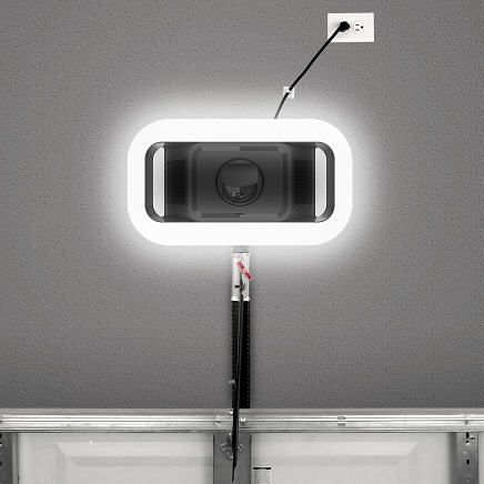 Garage door opener with a light, plugged into a wall outlet.