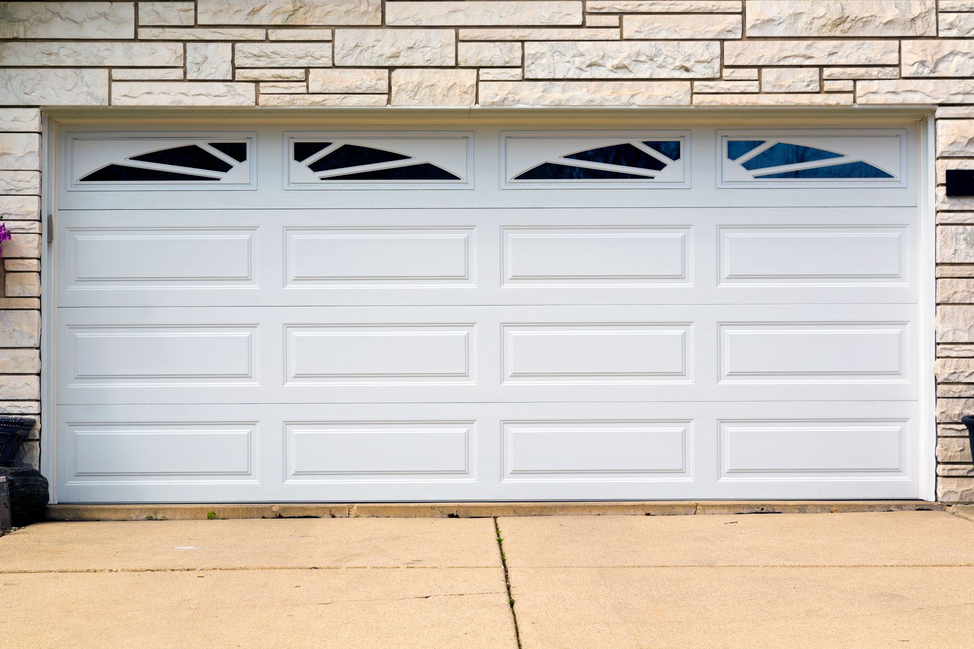 Front view of a white garage door installed on a home. Front view of a white garage door installed on a home.