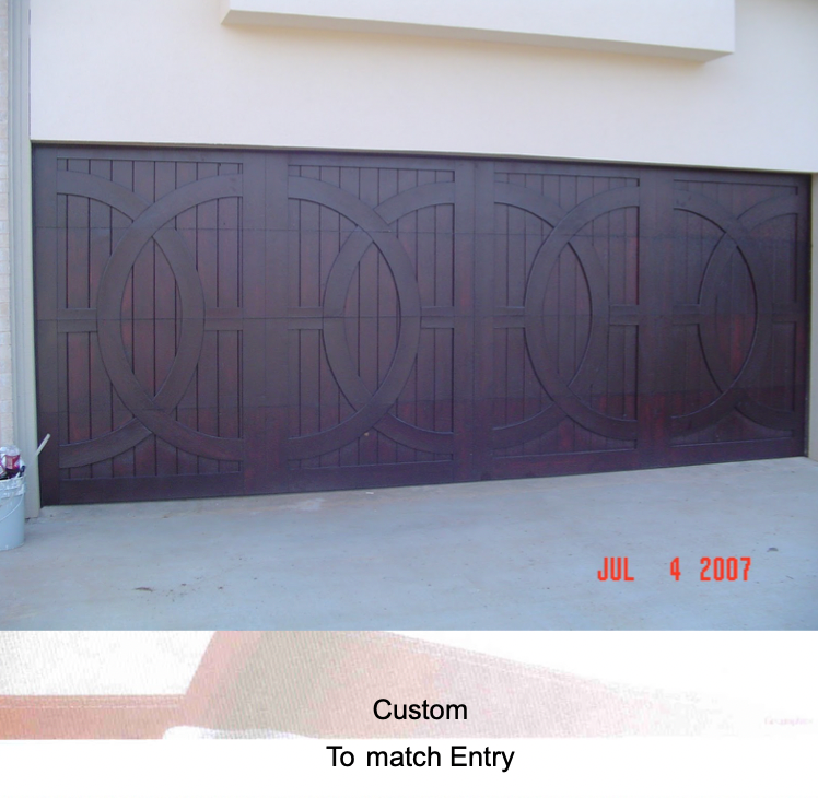 Dark wood garage door with decorative circular patterns, installed in a light-colored exterior wall.