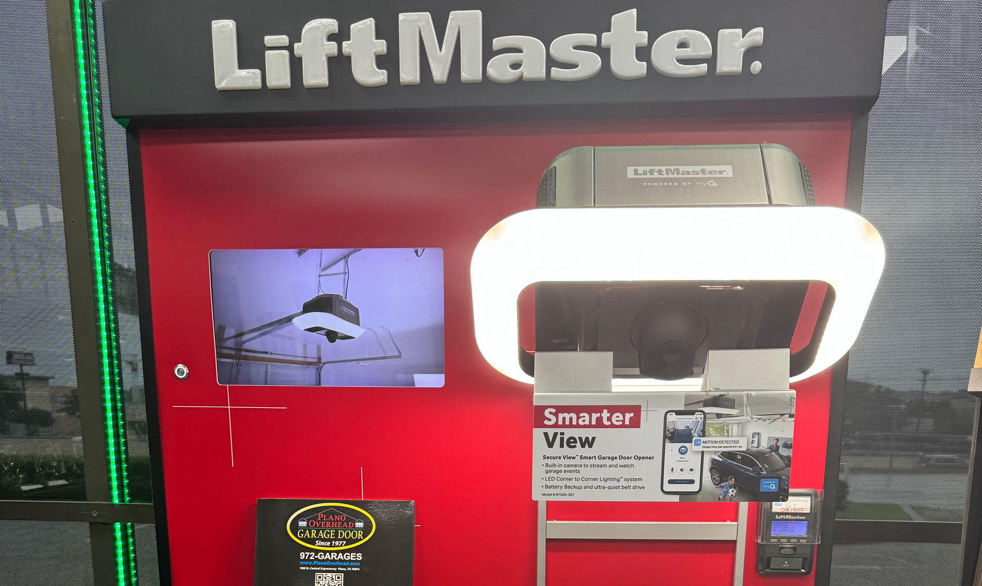 LiftMaster display with garage door opener, Smart View, and monitor, on red and black backdrop.