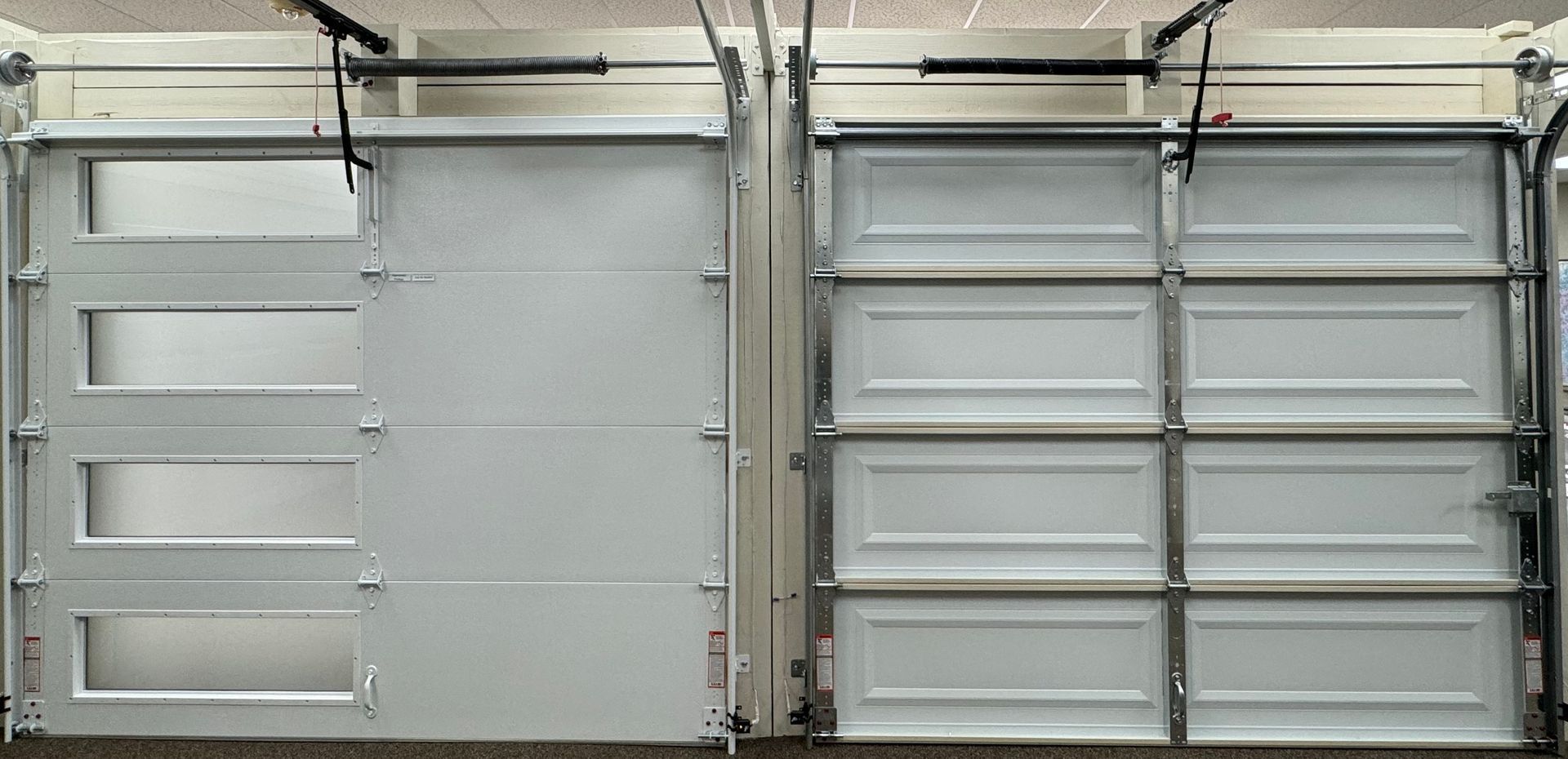 Two white garage doors with different window designs.