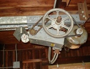 Garage door opener mechanism with chain and gears.