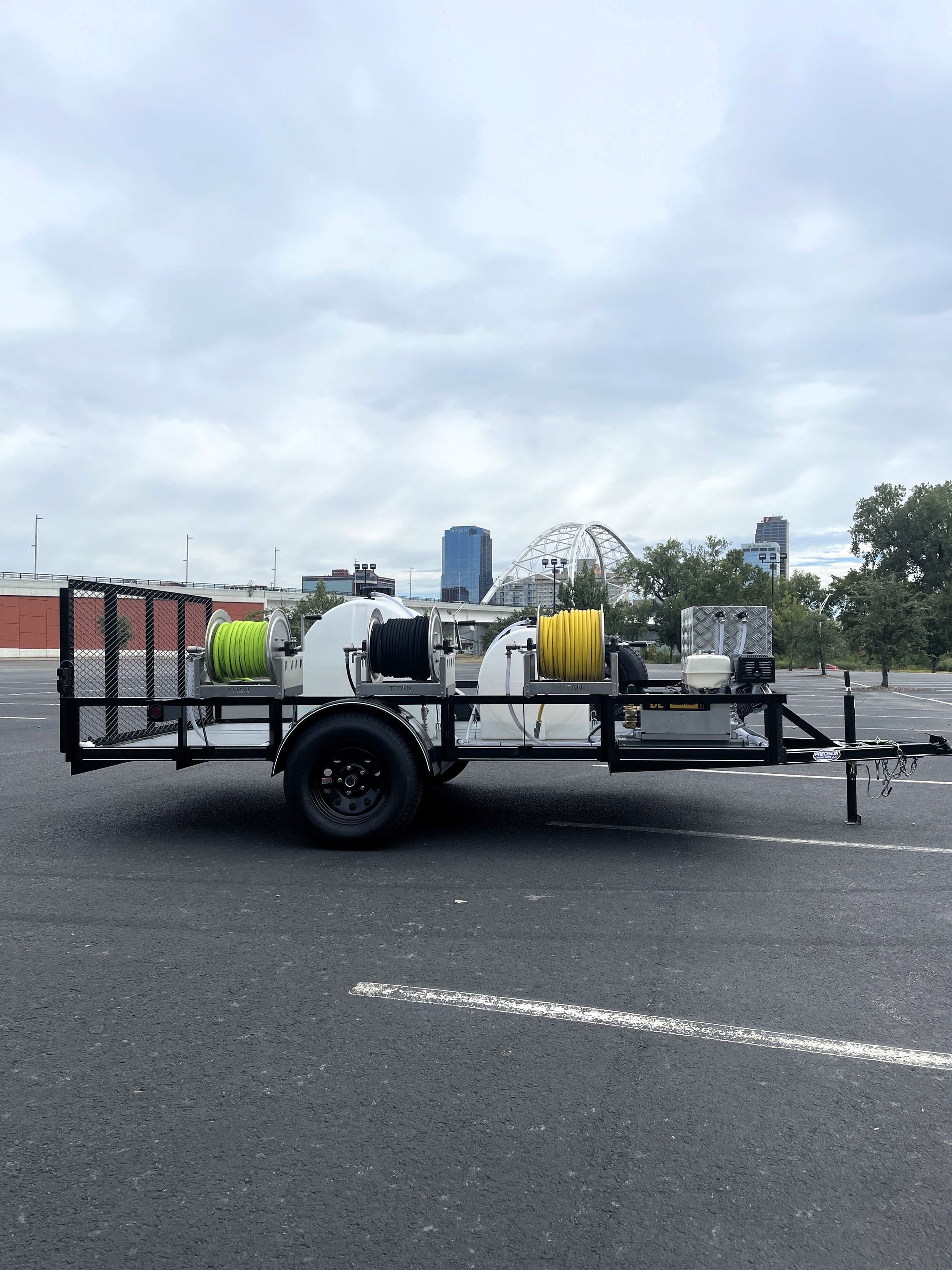 A trailer is parked in a parking lot with a city in the background