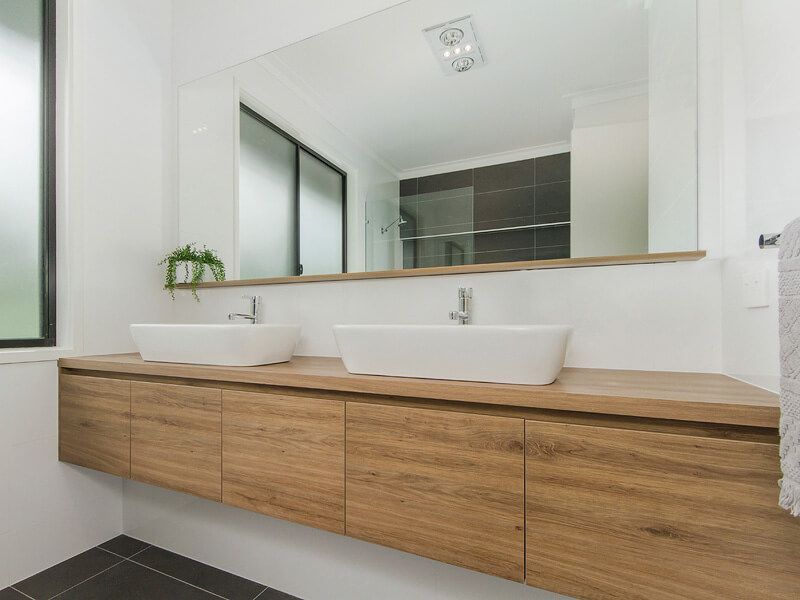 Modern bathroom with double sinks, wood vanity, and large mirror