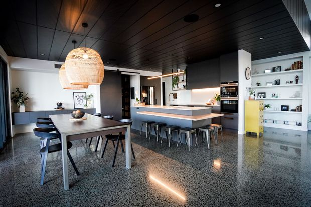 Modern kitchen with white cabinets, black island, pendant lights, and warm under-cabinet lighting. Modern kitchen with white cabinets, black island, pendant lights, and warm under-cabinet lighting.